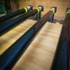Three pipes are lined up on a wooden floor.