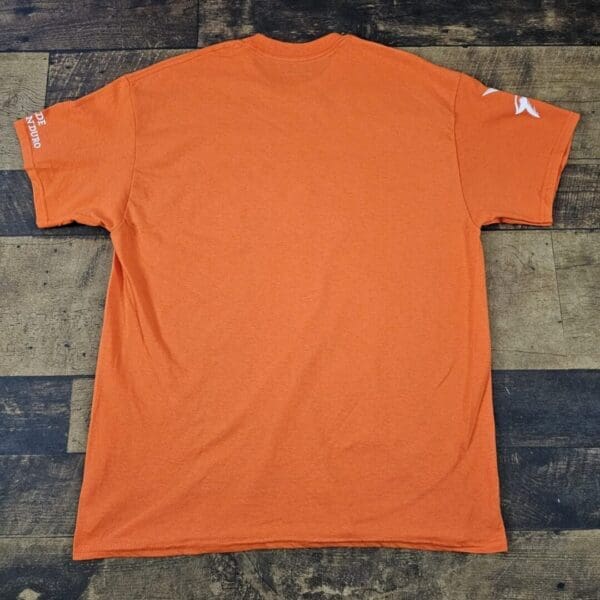 A orange shirt is sitting on the ground