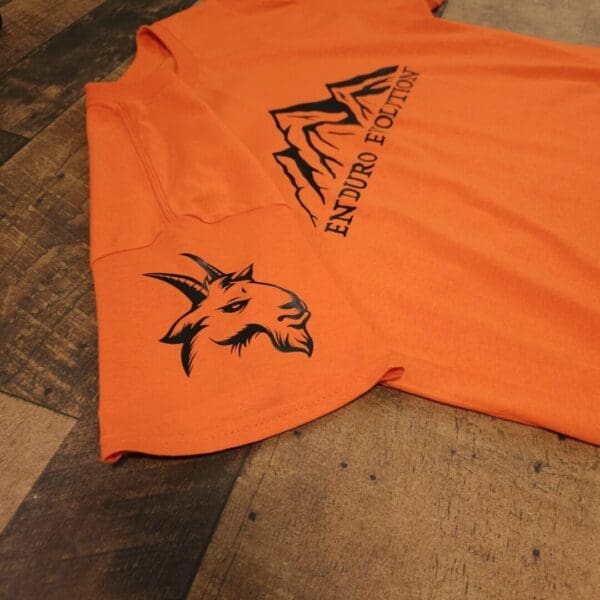A t-shirt that is laying on the floor.