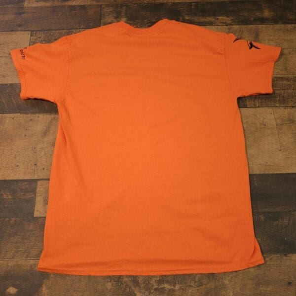A orange shirt is sitting on the ground
