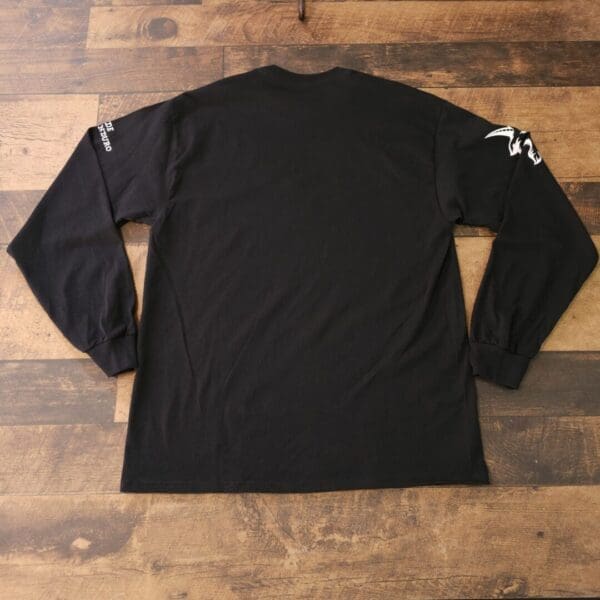 A black long sleeve shirt with a white logo on it.