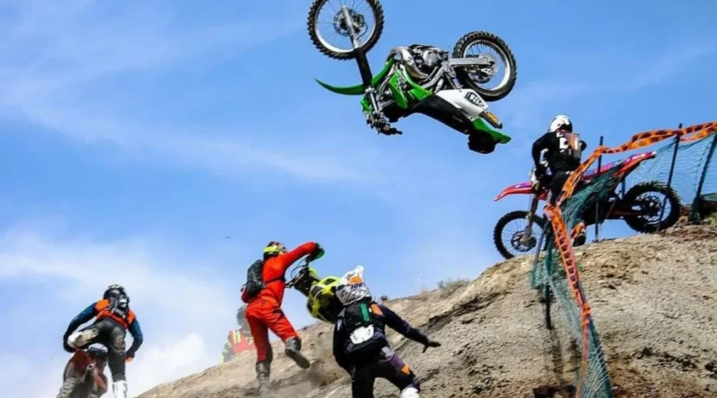 A man on a motorcycle jumping over some rocks