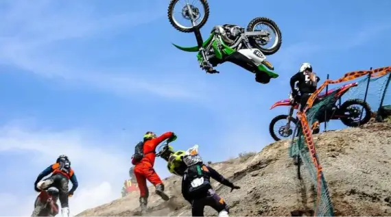 A man on a motorcycle jumping over some rocks